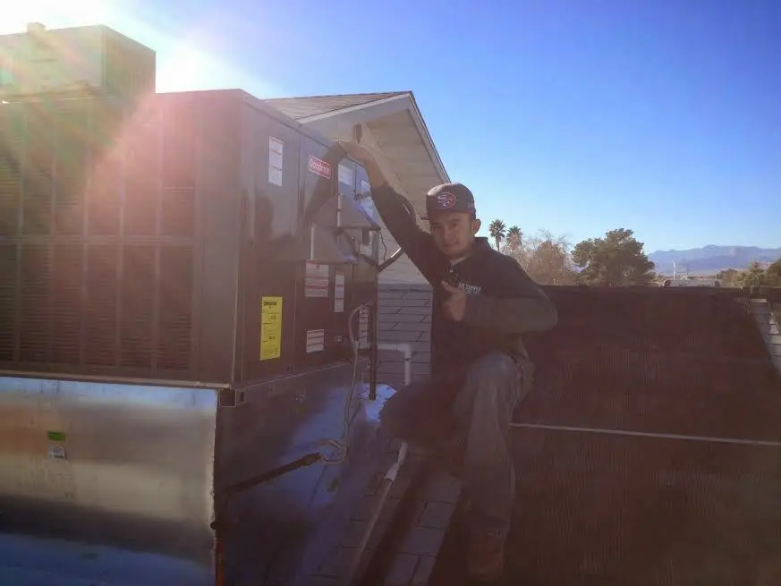 HVAC technician performing Air Duct Repair on a rooftop unit in Winslow